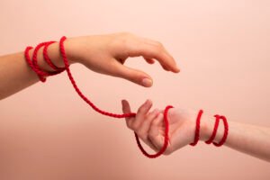 Human hands connected by a string to illustrate attachment styles in relationships